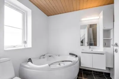 a white bathroom with a tub and a sink at 324-Harboore-Skalvej-4-b in Harboør