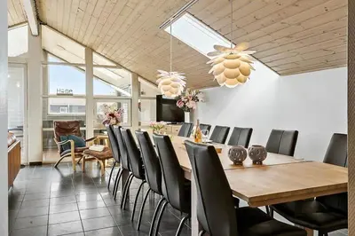 a dining room with a wooden table and chairs at 149-Harboore-Vejlby-Klit-175 in Harboør