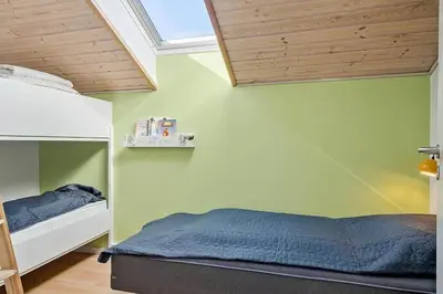 a bedroom with green walls and a bed and a window at 149-Harboore-Vejlby-Klit-175 in Harboør