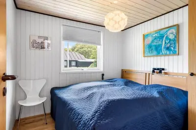a bedroom with a blue bed and a window at 605-Lemvig-Gjelleroddevej-65 in Lemvig