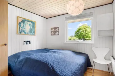 a bedroom with a blue bed and a window at 605-Lemvig-Gjelleroddevej-65 in Lemvig