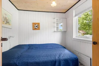 a bedroom with a blue bed and a window at 605-Lemvig-Gjelleroddevej-65 in Lemvig