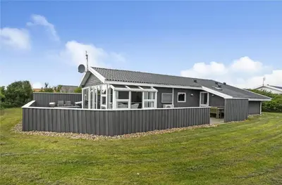 a house with a fence in front of a yard at 145-Harboore-Neerlandiavej-98 in Harboør