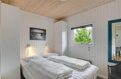 two beds in a white room with a window at 145-Harboore-Neerlandiavej-98 in Harboør