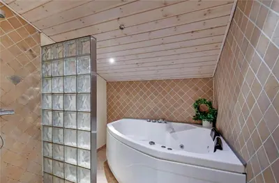a bath tub in a bathroom with a tile wall at 145-Harboore-Neerlandiavej-98 in Harboør