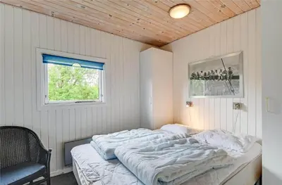 a bedroom with a bed in a room with a window at 145-Harboore-Neerlandiavej-98 in Harboør