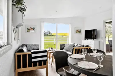 a living room with a table and chairs and a television at G103-Lemvig-Klovervej-3 in Lemvig