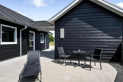 a patio with a table and chairs next to a building at G331-Lemvig-Myntevej-31 in Lemvig