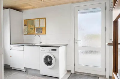 a white laundry room with a washer and dryer at G113-Lemvig-Nellikevej-13 in Lemvig
