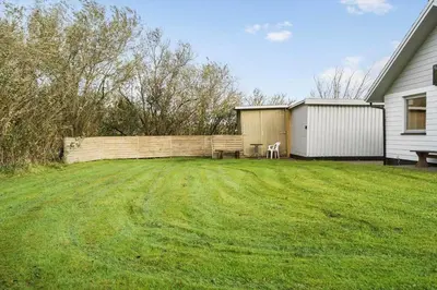a yard with a fence and a bench and a house at G113-Lemvig-Nellikevej-13 in Lemvig