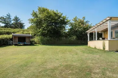 a yard next to a house with a shed at G171-Lemvig-Porsevej-71 in Lemvig