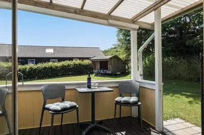 a patio with two chairs and a table on a porch at G171-Lemvig-Porsevej-71 in Lemvig