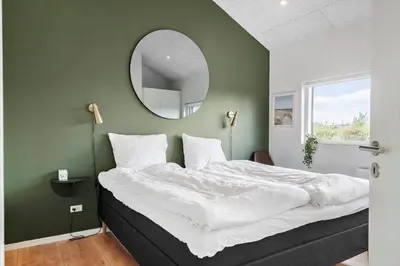 a bedroom with a large bed with a mirror at 237-Harboore-Neerlandiavej-17 in Harboør