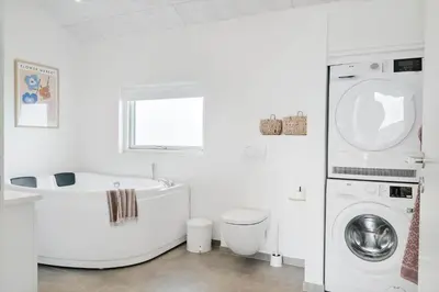 a white bathroom with a tub and a washing machine at 237-Harboore-Neerlandiavej-17 in Harboør