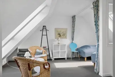 a living room with chairs and a staircase at 325-Harboore-Skalvej-4-c in Harboør