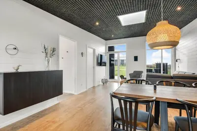 a dining room and living room with a table and chairs at G408-Lemvig-Violvej-8 in Lemvig