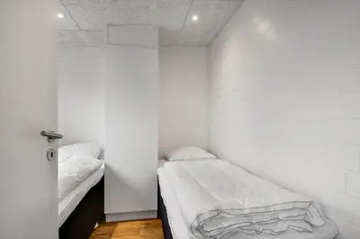 a small white room with two beds in it at G408-Lemvig-Violvej-8 in Lemvig