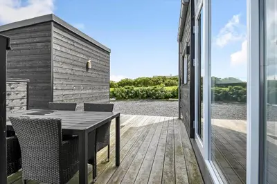 a patio with a table and chairs on a deck at G408-Lemvig-Violvej-8 in Lemvig