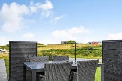 a table and chairs on a patio with a view of the ocean at G408-Lemvig-Violvej-8 in Lemvig