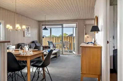 a living room with a table and chairs and a dining room at 138-Harboore-Neerlandiavej-6 in Harboør