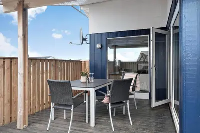 a patio with a table and chairs on a deck at 138-Harboore-Neerlandiavej-6 in Harboør