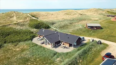 an overhead view of a house on a hill next to the ocean at 249-Harboore-Lucievej-8-c in Harboør