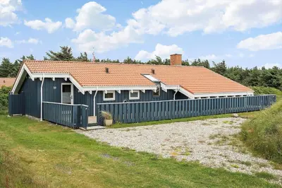 a house with a blue fence in front of it at 267-Harboore-Vaermlandvej-10 in Harboør
