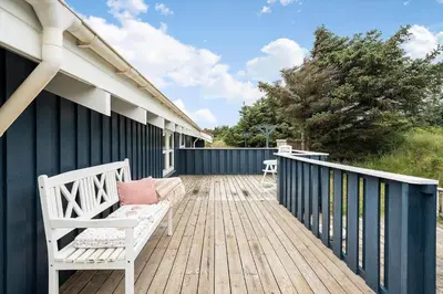 a wooden deck with a bench on a house at 267-Harboore-Vaermlandvej-10 in Harboør