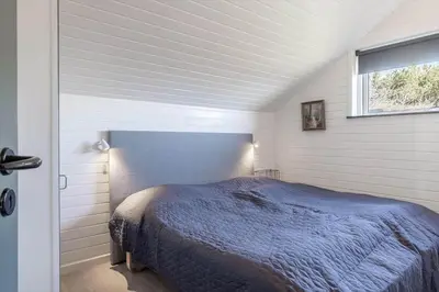 a bedroom with a blue bed in a white room at G246-Lemvig-Skovstjernevej-57 in Lemvig