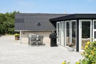 a screened in patio with chairs and a grill at G246-Lemvig-Skovstjernevej-57 in Lemvig