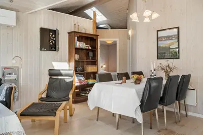 a dining room with a white table and black chairs at G139-Lemvig-Porsevej-39 in Lemvig