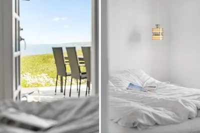 a bedroom with a bed and a view of the ocean at G217-Lemvig-Violvej-17 in Lemvig