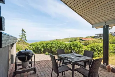 a patio with a grill and a table and chairs at G217-Lemvig-Violvej-17 in Lemvig