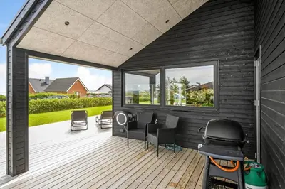 a screened in deck with chairs and a table at G307-Lemvig-Bynkevej-7 in Lemvig