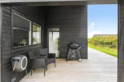a black house with a grill on a patio at G307-Lemvig-Bynkevej-7 in Lemvig