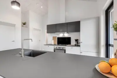 a white kitchen with a sink and a bowl of oranges at 255-Harboore-Vejlby-Klit-37-A in Harboør