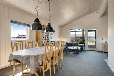 a dining room and living room with a table and chairs at 100-Harboore-Vejlby-Klit-51 in Harboør