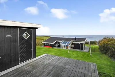 a house with a deck and a yard with a house at G230-Lemvig-Gyvelvej-30 in Lemvig