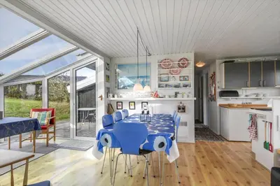 a dining room with a blue table and chairs at G230-Lemvig-Gyvelvej-30 in Lemvig