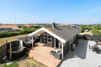 a house with a deck with a hot tub at 212-Harboore-Neerlandiavej-62 in Harboør
