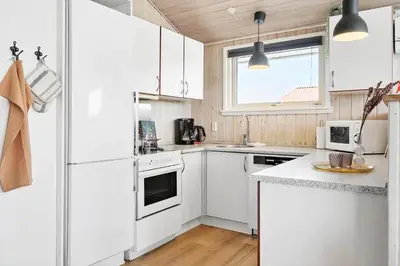 a white kitchen with white appliances and a window at 212-Harboore-Neerlandiavej-62 in Harboør