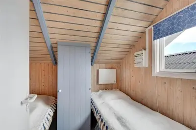 a small room with two beds and a window at 108-Harboore-Merchantvej-10-C in Harboør