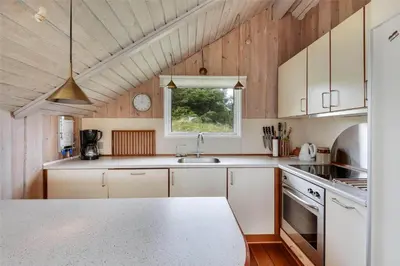 a kitchen with white cabinets and a window at 108-Harboore-Merchantvej-10-C in Harboør