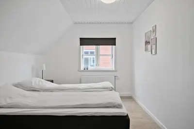 a white room with a bed and a window at 713-Thyboron-Vesterhavsgade-34 in Thyborøn
