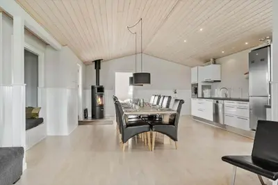 a dining room with a table and black chairs at 187-Harboore-Neerlandiavej-1 in Harboør