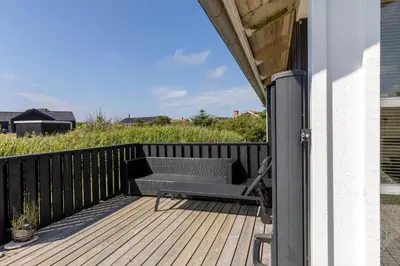 a patio with a chair and a table on a deck at 248-Harboore-Viktoriavej-16 in Harboør