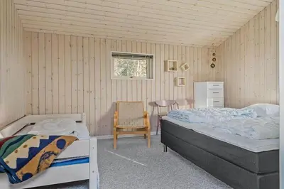 a bedroom with two beds and a table and a chair at 355-Harboore-Gloryvej-14 in Harboør