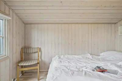 a bedroom with a bed and a chair in it at G305-Lemvig-Porsevej-105 in Lemvig