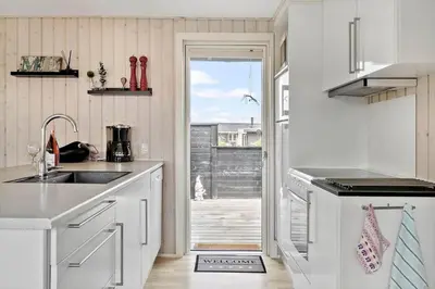 a kitchen with a sink and a door to a patio at G305-Lemvig-Porsevej-105 in Lemvig