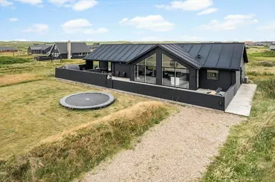 a black house in a field with a frisbee at 343-Harboore-Horizonvej-10-a in Harboør